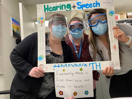 Staff at SSRH with a sign about hearing and speech month